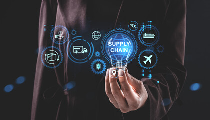 Businessman holding glowing hologram of supply chain logistics concept with digital transport icons on dark background representing modern technology..