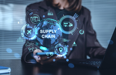 Supply chain management hologram concept with logistics icons over smartphone and globe in modern business environment on blurred office background.