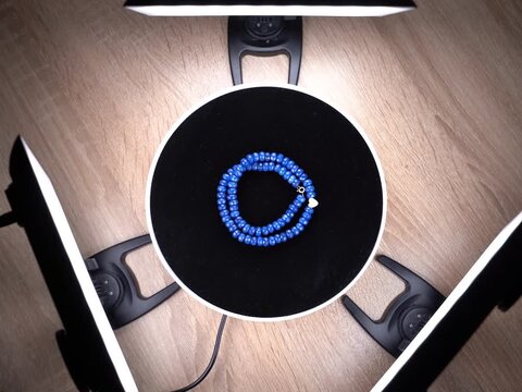 Shooting a product video. A bracelet is being spinning. Photography studio, light.