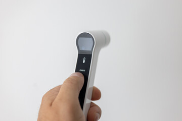 Infrared digital thermometer in hand on white background, modern smart healthcare device for measuring body temperature.