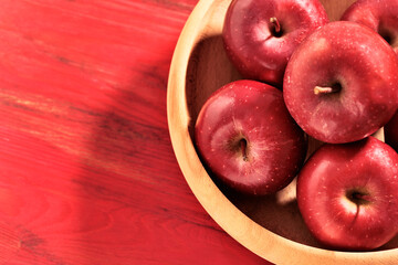 Red apples in wooden plate