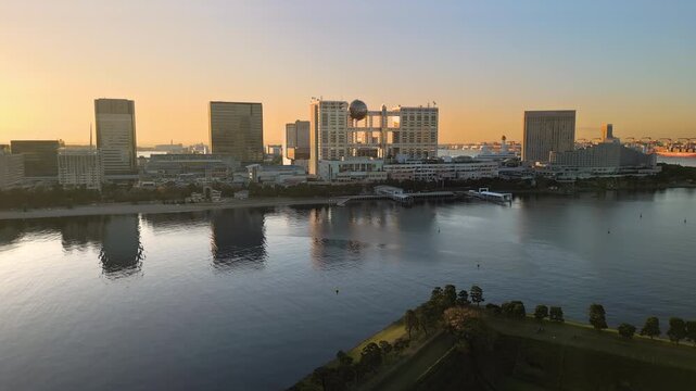 tokyo city bay aerial view drone at dawn,flying over daiba park,odaiba ward waterfront in the background