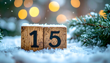 Number 15 on wooden cubes on snowy surface with fir tree branches, cozy festive winter scene.