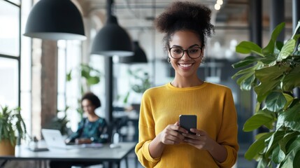 Confident Professional Woman Using Smartphone in Modern Office with Green Plants and Colleague in Background