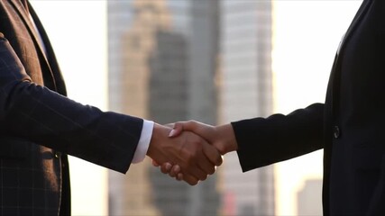 Business handshake signifies partnership and success against an urban cityscape backdrop - Powered by Adobe