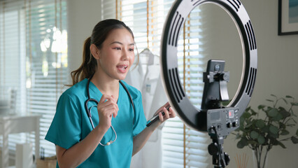Young adult woman Gen Z asia people anti aging expert modern nurse live talk viral video selfie camera on mobile phone app mental health care. Online sharing digital virtual asian vlogger filming.