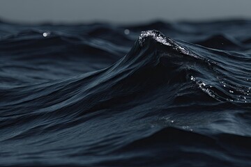 Dark ocean waves cresting, illuminated with subtle reflections