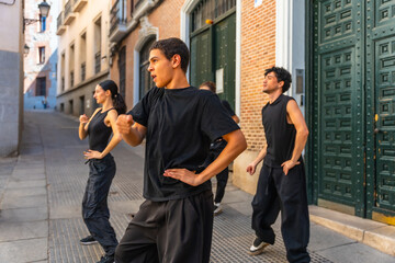Group of young dancers performing urban choreography on street
