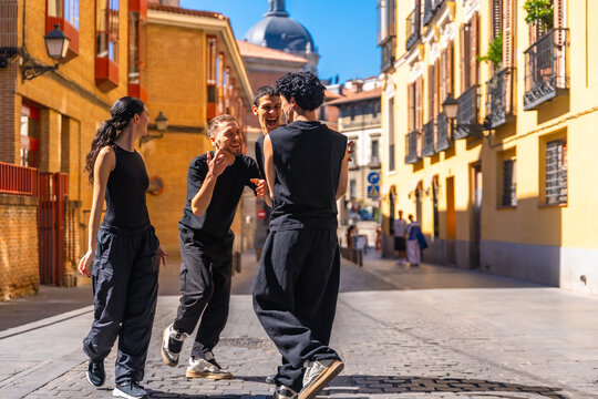 Young friends dancing and laughing on a city street in madrid