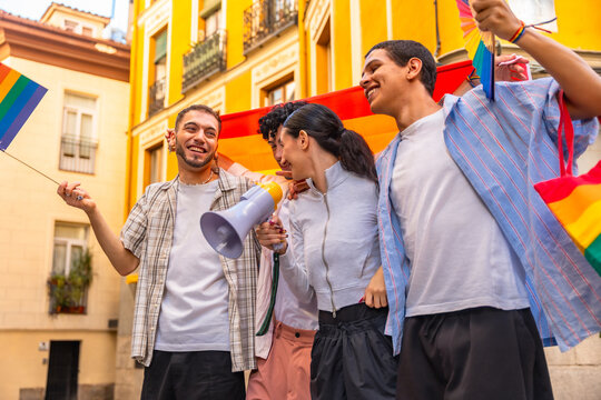 Diverse friends celebrating pride with rainbow flags and megaphone