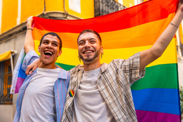 Gay couple celebrating love and pride with rainbow flag