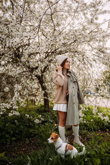 A girl with a dog against a backdrop of a blossoming tree 7263.