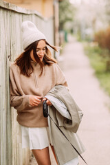 A girl in a beige sweater and a white skirt 7276.
