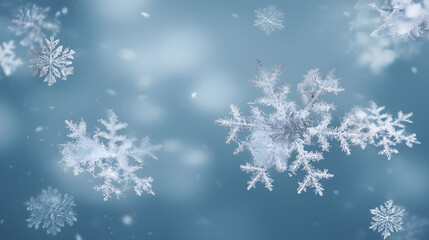 Delicate snowflakes float against a soft blue background, creating a serene winter scene and capturing the beauty of nature.