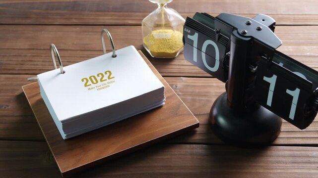 2022 Calendar and Hourglass Time Management Concept on Wooden Desk