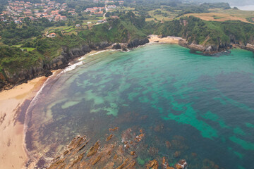 Aerial view of Amio Beach and Arama Beach (Playa de Arama) on sunny summer day. Pechon, Cantabria, Spain.