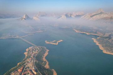 Aerial view of Riaño reservoir and mountains on misty summer morning. Montaña de Riaño and Mampodre Regional Park, Castile and Leon, Spain.