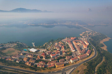 Aerial view of Riaño town and reservoir on foggy summer morning. Castile and Leon, Spain.