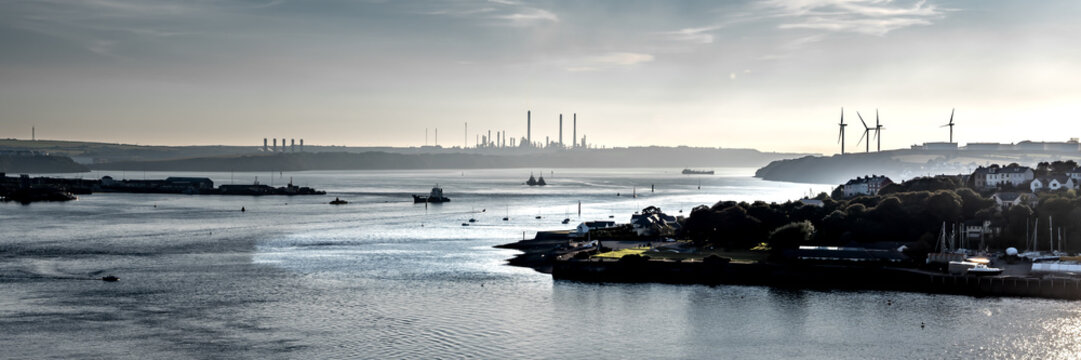 View From Cleddau Bridge To River Estuary With Pembrokshire Docks, Wind Turbines And Factories In Wales, United Kingdom
