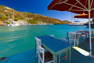 Fototapeta premium Idyllic Coastal Village with Turquoise Waters and Outdoor Dining, Greek island of Lefkada