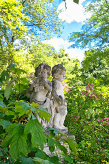 zwei Engel machen Musik inmitten eines blühenden Strauches  auf einem Münchner Friedhof © Blende8