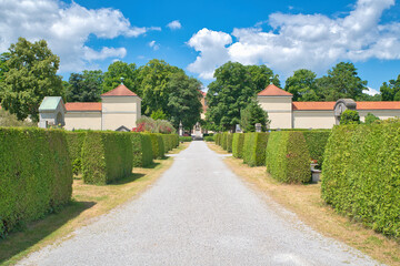 Wunderschöner gepflegter Friedhof mit schönen Hecken und Blick zur Kapelle auf einem Münchner Friedhof © Blende8