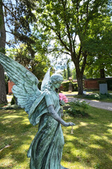 schöner großer Engel mit frischen Blumen im Arm auf einem Münchner Friedhof © Blende8