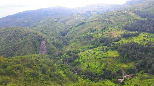 The rugged, diverse highlands of Aileu, Timor-Leste, seen from above. An aerial view shows the varied vegetation, contours, and dry areas of this remote mountain landscape