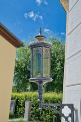 sehr schöne reich verzierte Grablaterne an einem Arm am Grabstein auf einem Friedhof in Rosenheim  © Blende8