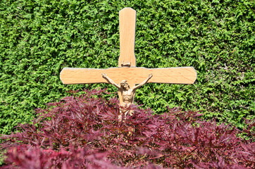 schlichtes Holzkreuz mit der Jesusfigur vor sehr schöner Kulisse  auf einem Friedhof in Rosenheim  © Blende8