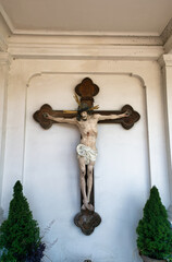 schönes großes Farbiges Kreuz mit der Jesusfigur an einer Wand auf einem Friedhof in Rosenheim  © Blende8