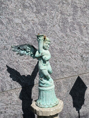 schöner kleiner Engel mit eine Füllhorn in Licht und Schatten auf einem Friedhof in Rosenheim  © Blende8