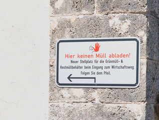 Hinweisschild für die Müllentsorgung neben dem Eingang zu einem Friedhof in Rosenheim  © Blende8