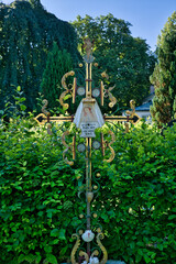 sehr alter Reich Verziertes Eisenkreuz farbiges Bild auf einem alten Friedhof in Landsberg Lech © Blende8
