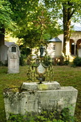 kleiner alter Grabstein mit wunderschön verziertem Eisenkreuz auf einem alten Friedhof in Landsberg Lech © Blende8