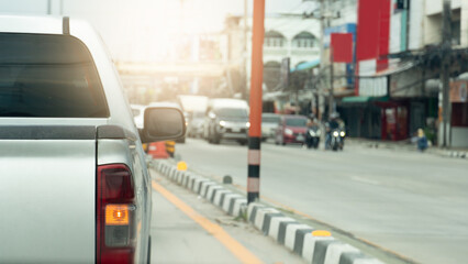 Rear side of pickup car with turn on right signal. Median strip painted in a mysterious White and black color. Opposite road with cars prepare to drive after green light open. Environment in the city,