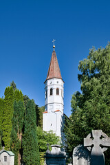 schöner Kirchturm hinter Grabsteinen auf dem alten Friedhof in Landsberg Lech © Blende8