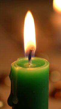 Lighting a green candle for a Kwanzaa celebration. Close-up of a flame for a holiday ritual. African American cultural tradition concept. Vertical video