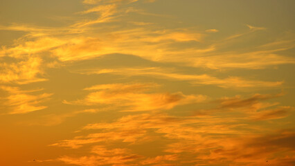 Obraz premium Golden sunset due to the sunlight reflecting off the middle and high clouds.