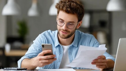 Concentrated Review: A focused individual meticulously reviews paperwork while multitasking on a phone, exemplifying modern information management and attention to detail. - Powered by Adobe