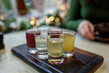 Assorted craft shots on rustic wooden tray at bar