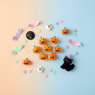 Minimalist and Playful Halloween Flat Lay with Pumpkins, Ghost, and Cat on Pastel Background
