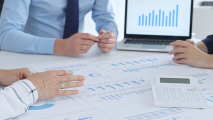 Accouters analyzing financial data using charts, graphs, and reports during an office meeting, collaborating on strategy. Business people concept