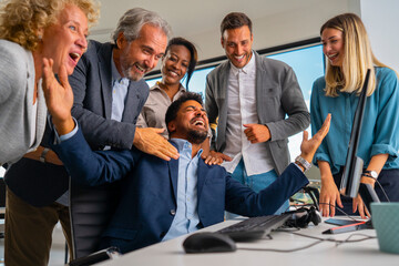 Diverse business team cheering and celebrating a major achievement, success, or victory together in a modern office environment, demonstrating teamwork and happiness