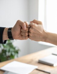 Two fists bump in agreement, a sign of collaboration and success, Symbolic gesture of unity and teamwork in a professional setting
