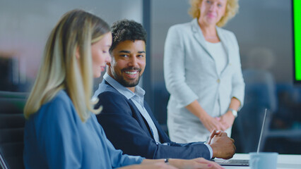 Diverse business professionals collaborating during an informal meeting in a contemporary office setting, engaging in discussion and sharing ideas, fostering teamwork and productivity