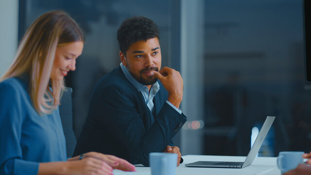 Diverse business professionals having a corporate meeting, discussing ideas and collaborating on a new project inside a modern office with a laptop on the table