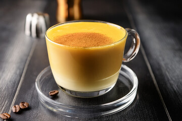 Beautiful Vietnamese egg coffee served in elegant glass cup surrounded by spices encouraging educational interest in culinary traditions and cultural heritage
