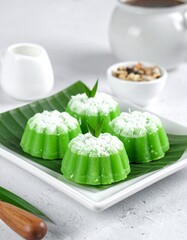 Traditional Indonesian Kue (Cake) with Pandan Flavor, Delicious Bite-Sized Treats on a Serving Plate , Authentic Asian Dessert Presentation: Kue Bugis on Banana Leaves for a Delightful Still Life