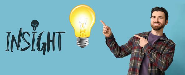 Young man pointing at something on blue background